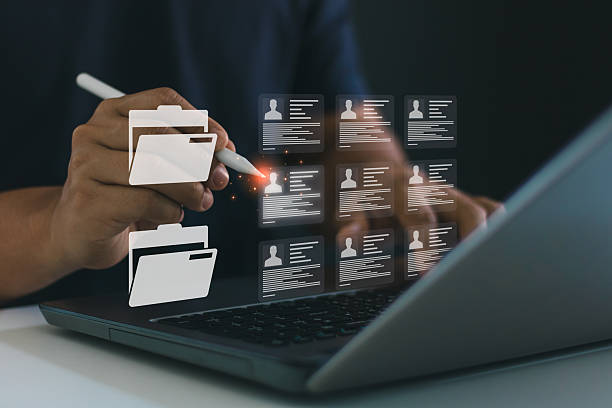 c4 Business professional managing digital employee record using stylus and laptop. Digital file management system, online document access, cloud-based HR database solution, secure corporate information.
