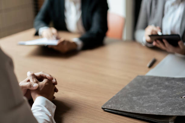 HR manager woman reading resume and asking questions with male candidate while job interviewing.